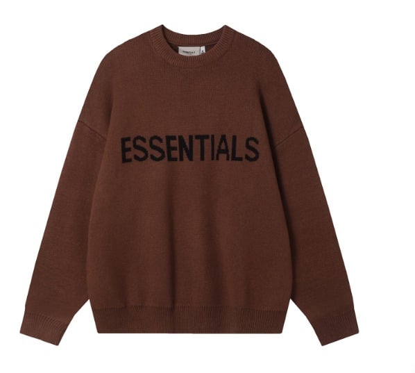 A Fear of God Essentials Knitted Sweater in harvest brown with "ESSENTIALS" written in black across the chest, featured against a white background.