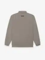 The Wool Nylon Track Jacket, shown from the back in a plain white background, is beige and features long sleeves. It has an elastic waistband and cuffs, along with a small rectangular patch located at the upper center near the collar.