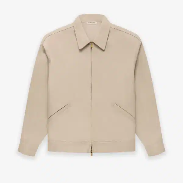 A Fear of God Taupe Zip Denim Jacket 'Dusty Beige', featuring long sleeves, a pointed collar, and two diagonal front pockets, displayed on a plain white background.