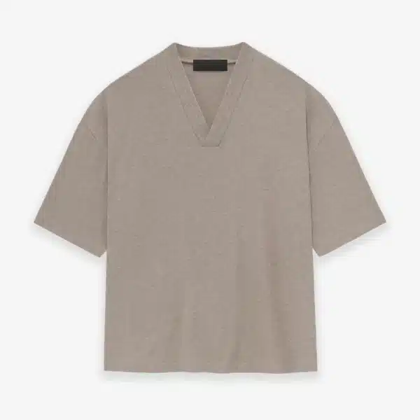 The Fear of God Essentials V-Neck T-Shirt 'Core Heather', featuring a plain beige design with short sleeves, is displayed on a white background.