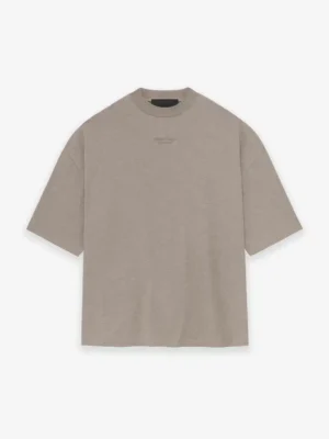 The Fear of God Essentials T-Shirt 'Core Heather' is an oversized beige t-shirt featuring short sleeves and a crew neckline, showcased against a white background.