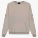 Introducing the FG Essentials Crewneck Sweatshirt 'Core-Heather', a soft and comfortable beige sweatshirt. It boasts a minimalistic design with long sleeves, a large front pocket, and subtle lettering on the sleeves.