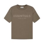 The Fear of God Essentials T-Shirt 'Harvest' is a khaki-colored tee featuring the words ESSENTIALS and FEAR OF GOD printed on the front in a subtly darker shade. It boasts a simple, classic design with short sleeves.