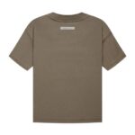 The back view of the Fear of God Essentials T-Shirt 'Harvest' features a plain brown design with a rectangular label near the neckline, laid flat against a white background.