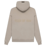 The Fear of God Essentials FG Hoodie 'Core-Heather' features a beige color with "FEAR OF GOD" text embossed on the back, along with a drawstring hood and long sleeves.