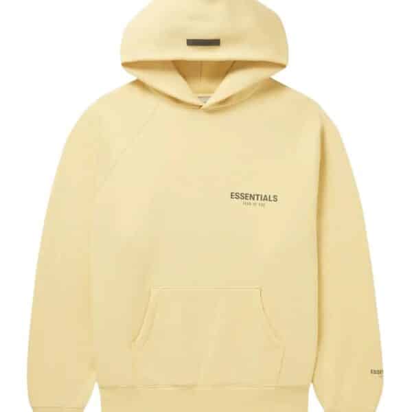 The Fear Of God Blend Jersey Essentials Hoodie is a light yellow hoodie featuring a front pocket, with "Essentials" and "Fear of God" printed in small black letters on the front and sleeve. It offers a relaxed fit and comes with a drawstring hood.